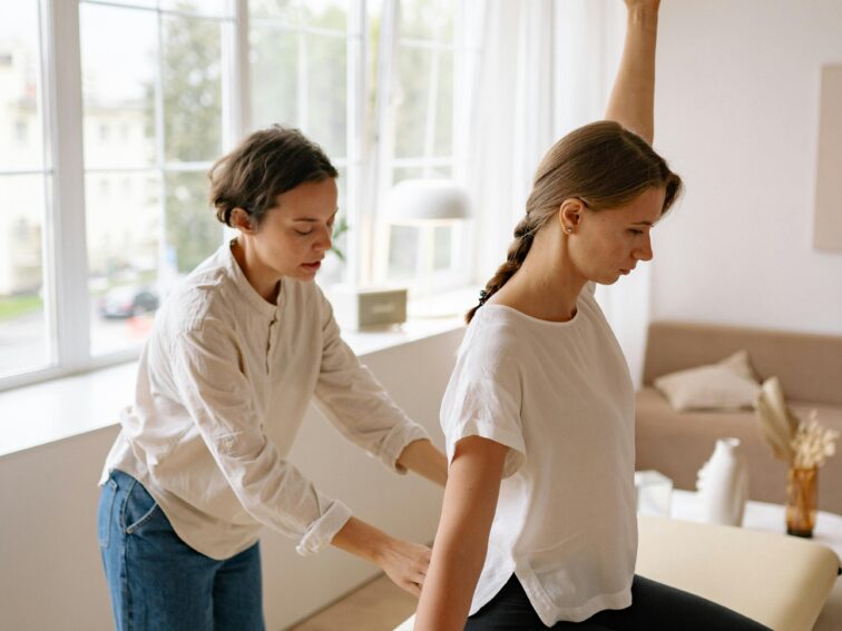 A therapist provides back treatment to a client in a serene indoor setting.