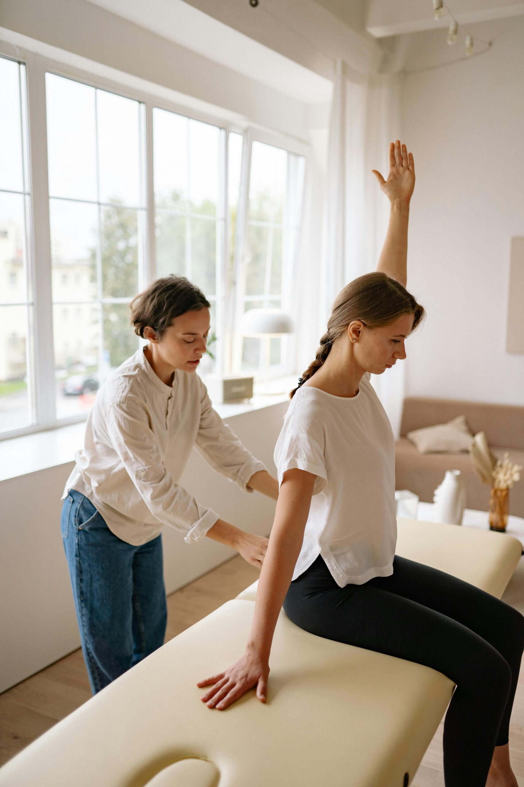 A therapist provides back treatment to a client in a serene indoor setting.