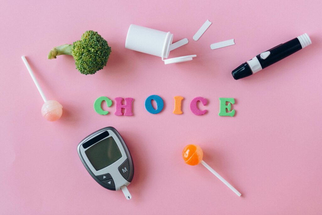 Word "Choice" Made of Colorful Letters Lying among Diabetes Equipment, Sweets and Broccoli